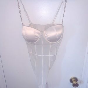 A white mesh with chain strap bodysuit